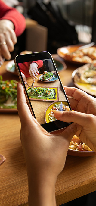 close-up-hands-using-smartphone taking picture of food